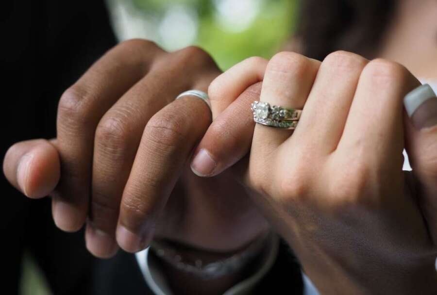 closeup-of-a-couple-with-wedding-rings-holding-hand